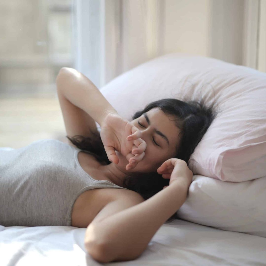 woman-in-gray-tank-top-lying-on-bed-3807982